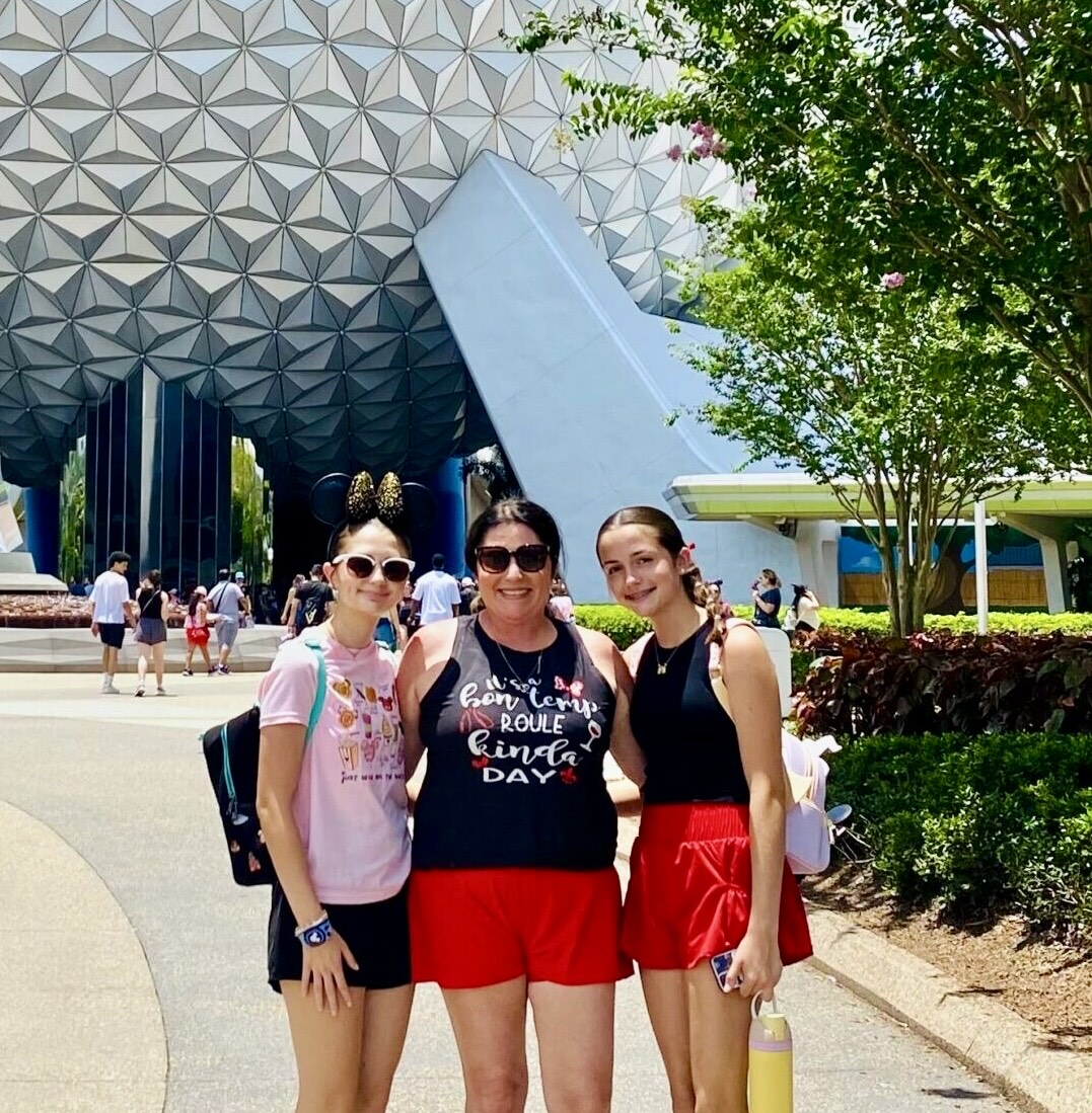 Girls standing in front of Spaceship Earth at EPCOT during a Disney vacation.