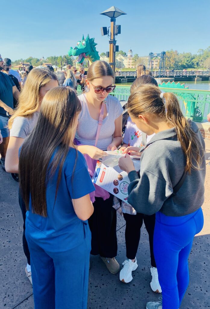 Friends enjoying a fun challenge at the Disney Springs Christmas Tree Stroll.