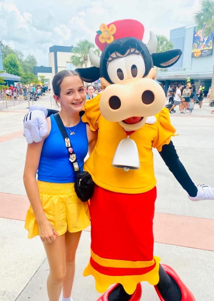 Girl smiling with Disney characters at Animation Courtyard in Hollywood Studios.
